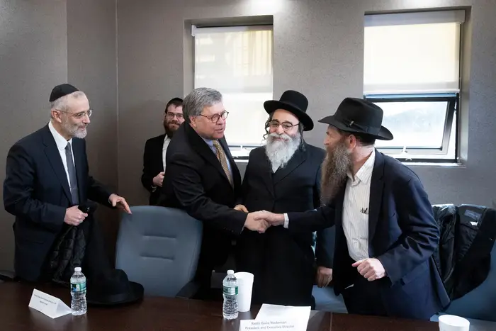Attorney General William Barr, center, shakes hands with Rabbi Eli Cohen, right, at a meeting with Jewish leaders at the Boro Park Jewish Community Council in Brooklyn, NY on January 28th.